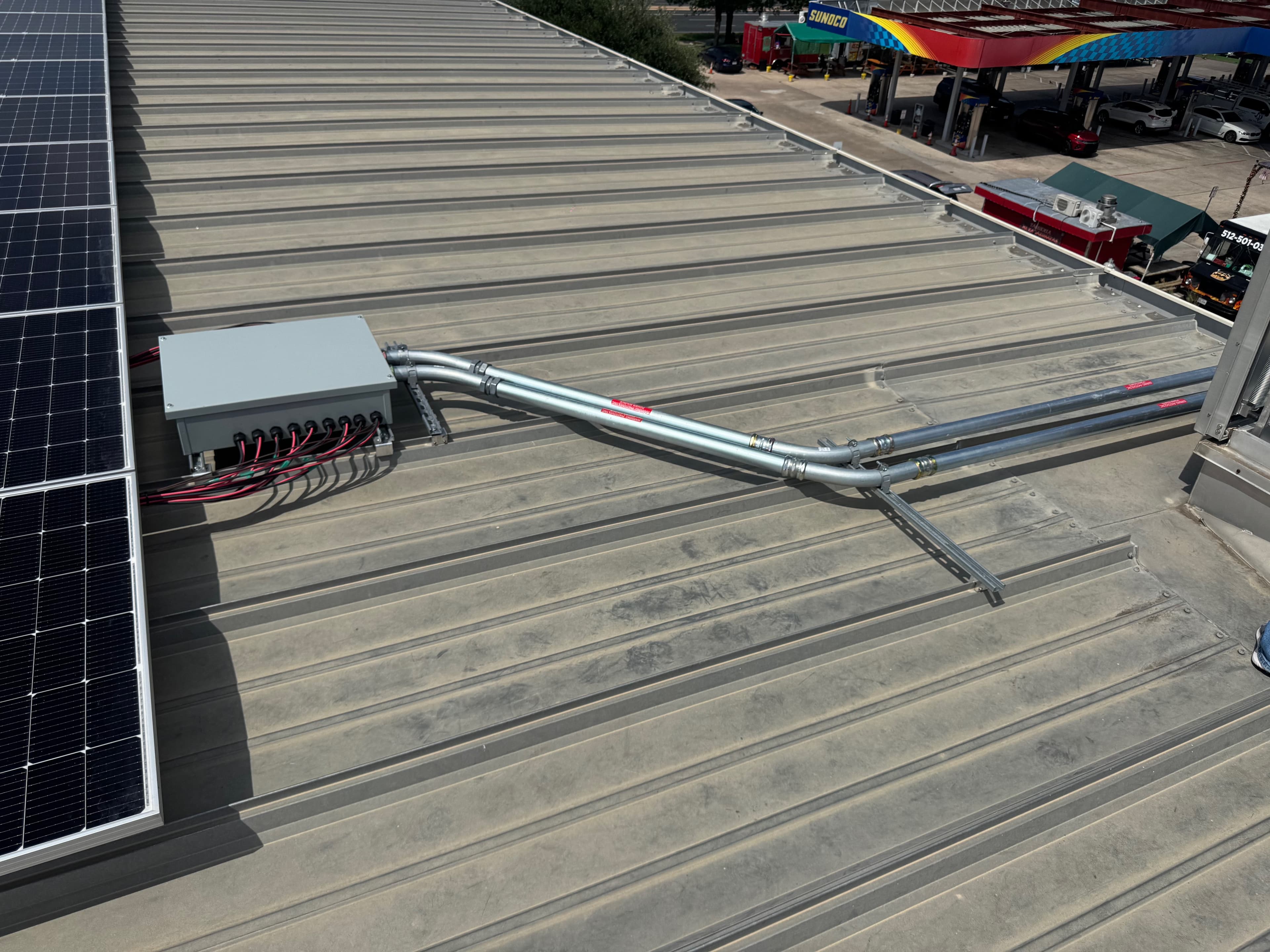 Combiner box and labeled conduit runs on a commercial metal roof