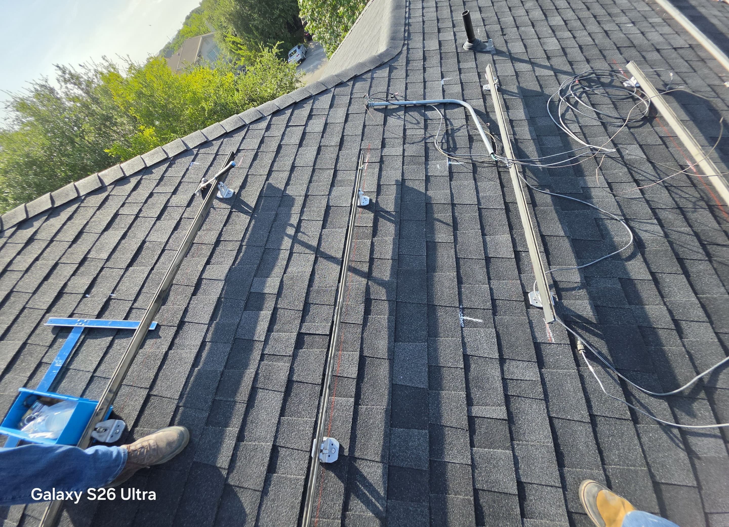 Layout chalk marks, conduit, and mounting rails documented on a shingle roof